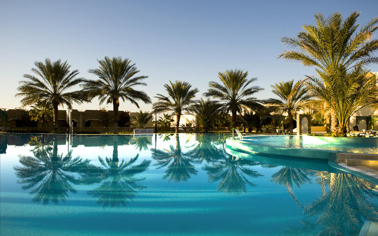 Palmen an einem luxoriösen Pool in Djerba © parkisland / Shutterstock.com