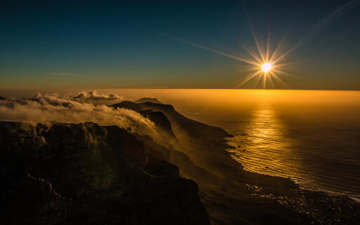 Sonnenuntergang mit Blick auf den Tafelberg und die Küste von Kapstadt, Südafrika © Pocholo Calapre / Shutterstock.com
