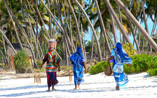 Frauen in bunten Kleidern am Sandstrand © Dimitry Sukhov / Shutterstock.com