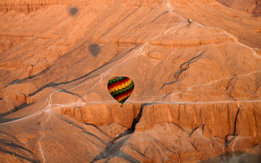 Ein Heißluftballon über der Wüste von Luxor © Endless Traveller  / Shutterstock.com