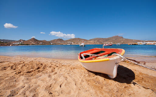 Buntes Fischerboot am sonnigen Sandstrand © Sogno Lucido